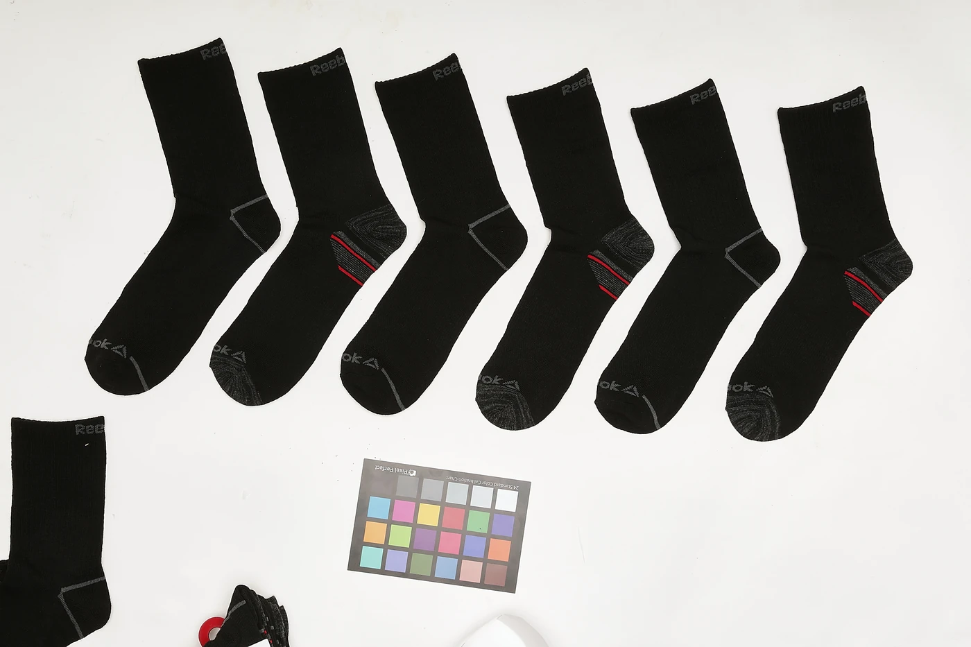 Sock range as shot — scattered on a studio table with a colour checker and stray samples
